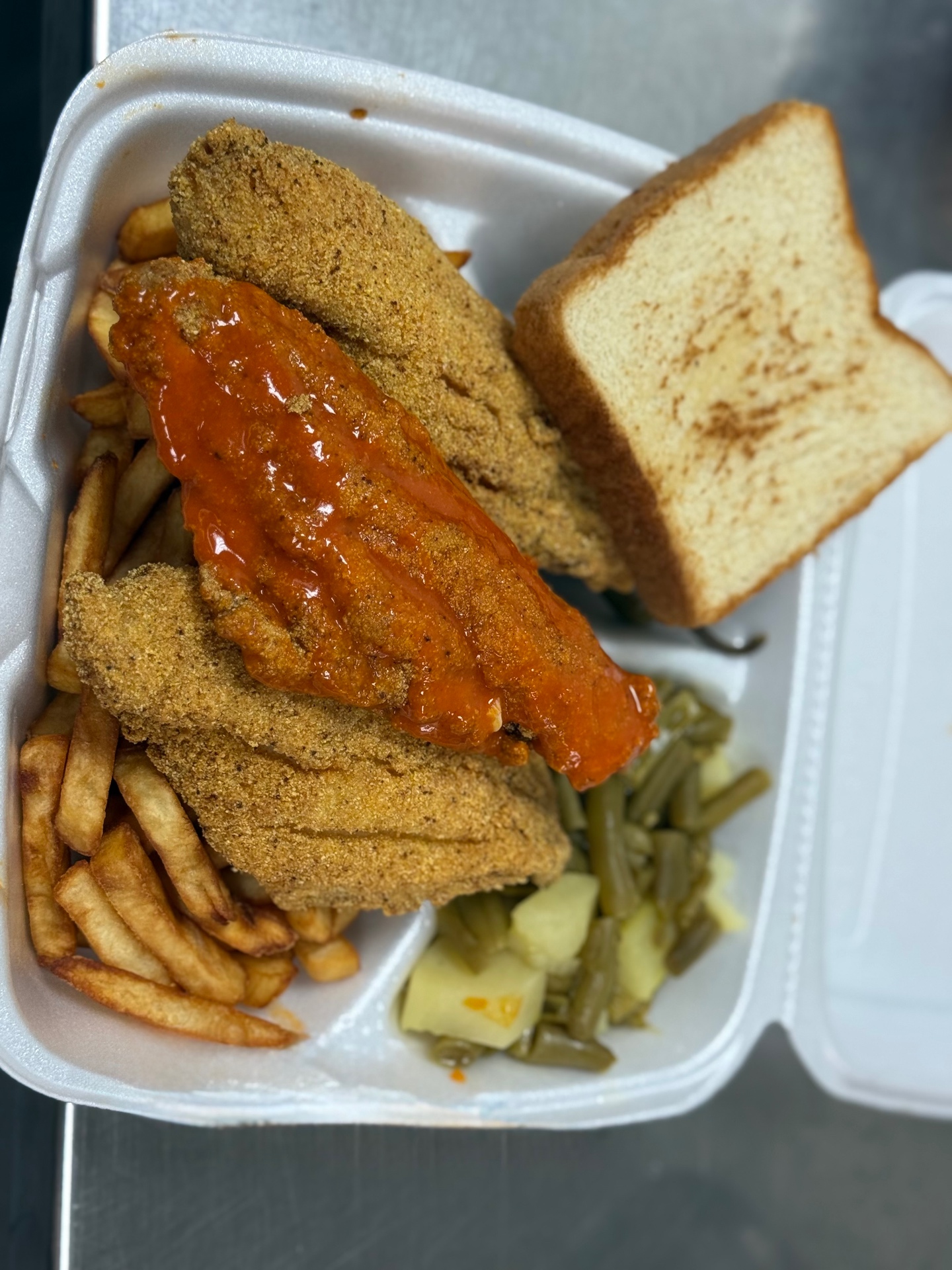 Fried catfish with hot sauce, fries, and green beans